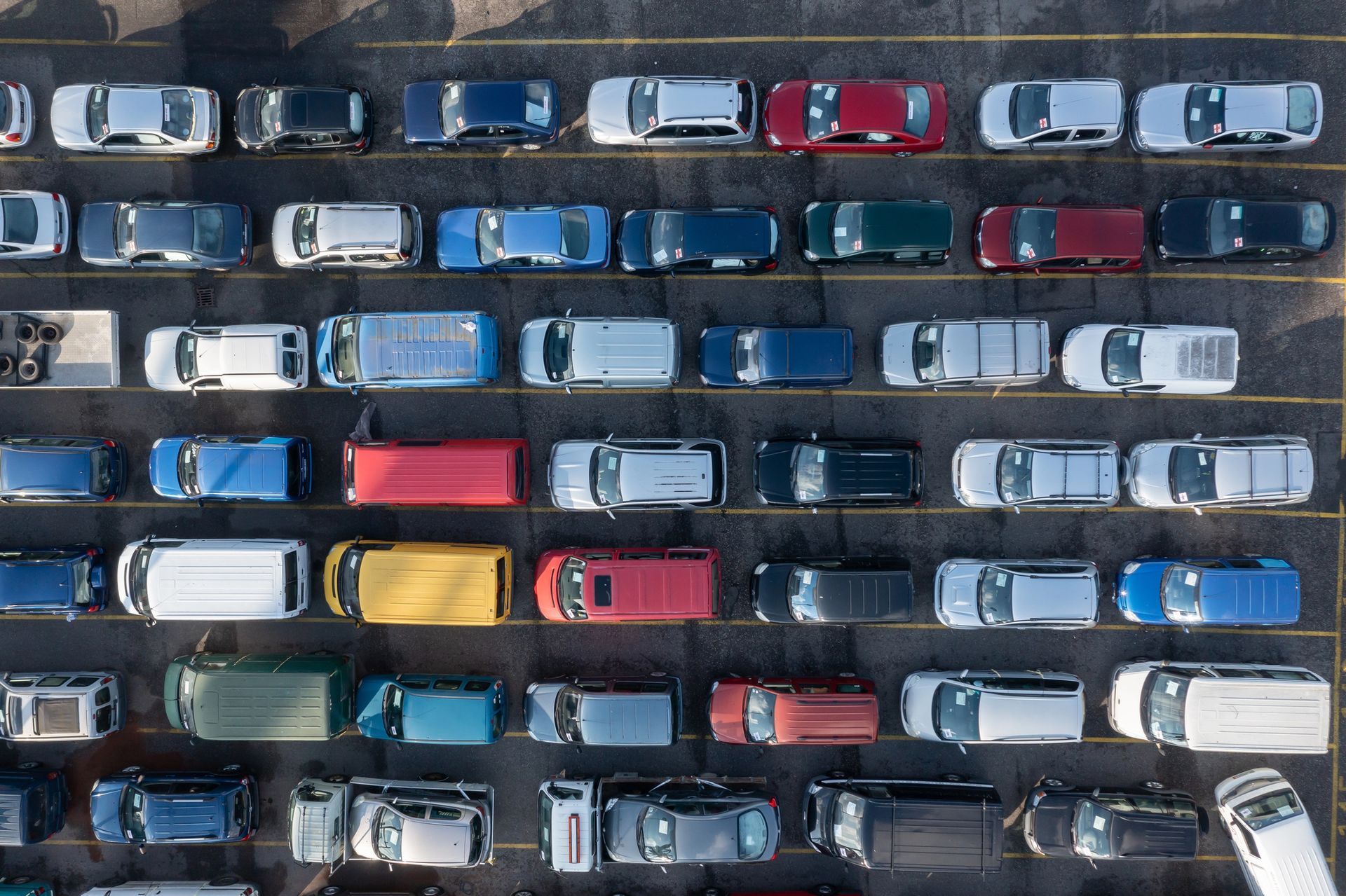 Vista aerea di auto parcheggiate allineate in fila in un parcheggio