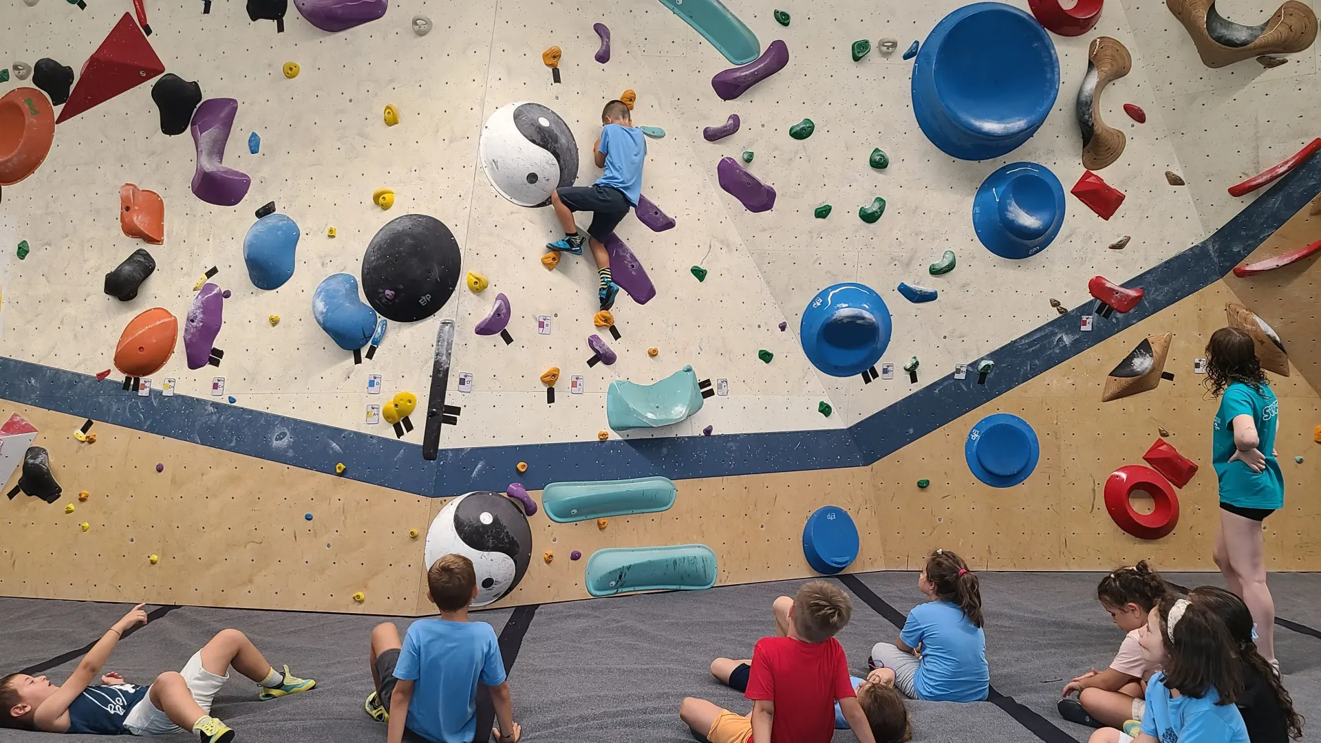 bambino che fa bouldering in palestra di arrampicata