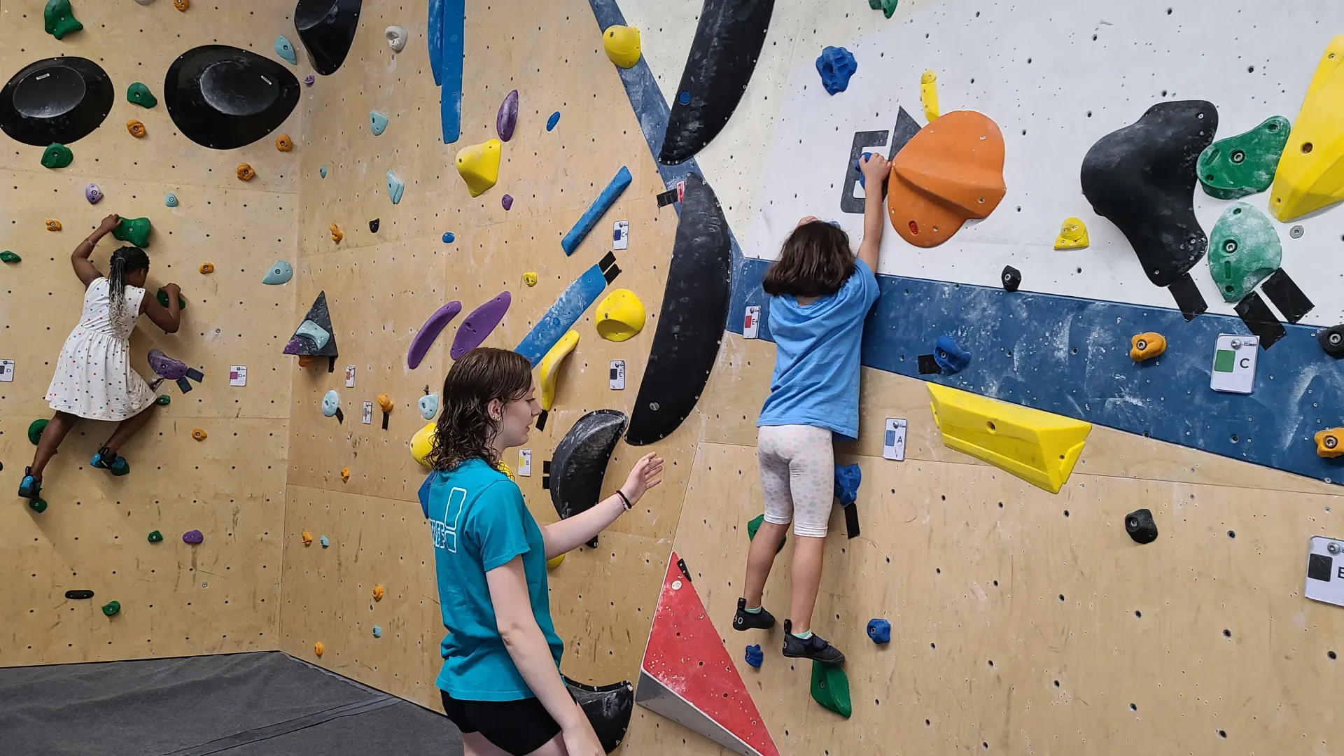 bambine che fanno bouldering in palestra di arrampicata