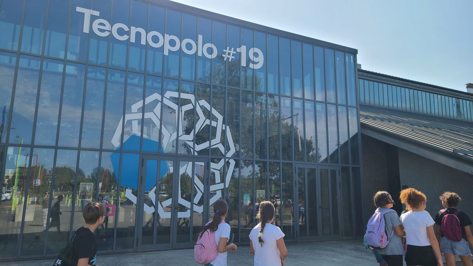 bambini  e bambine che camminano davanti al tecnopolo 