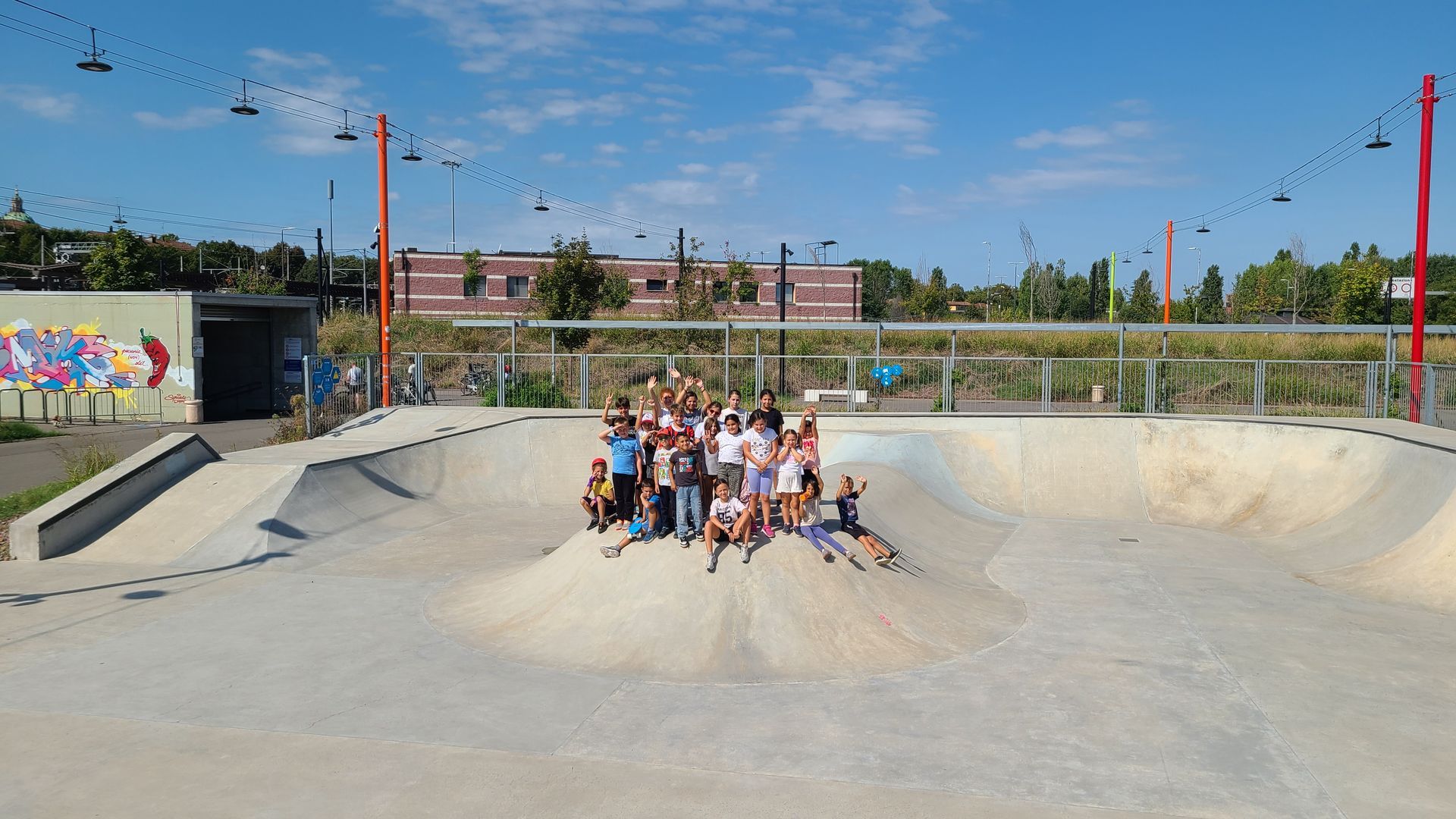 foto di gruppo di bambini e bambine allo skatepark