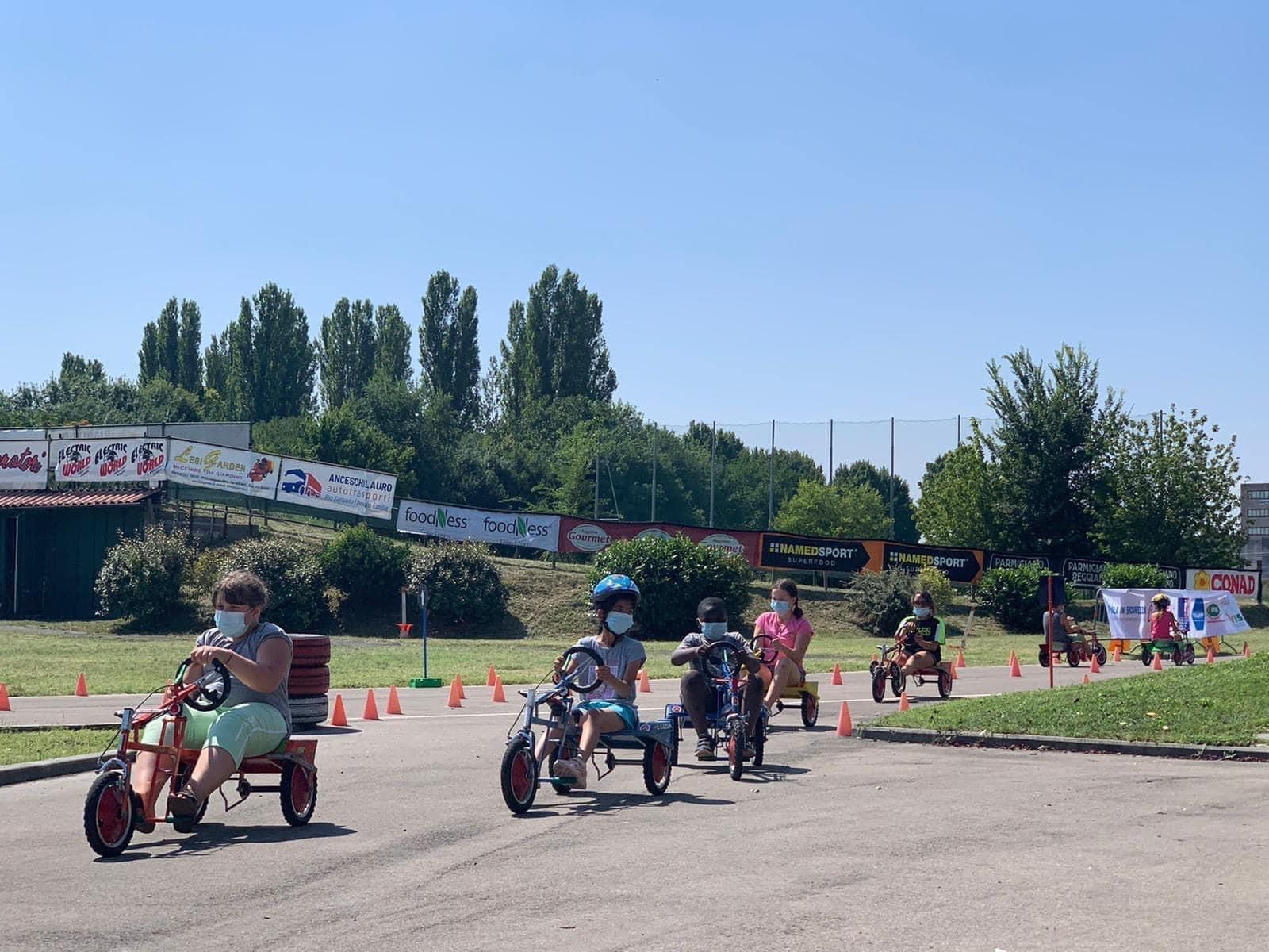 bambini e bambine che vanno sul triciclo