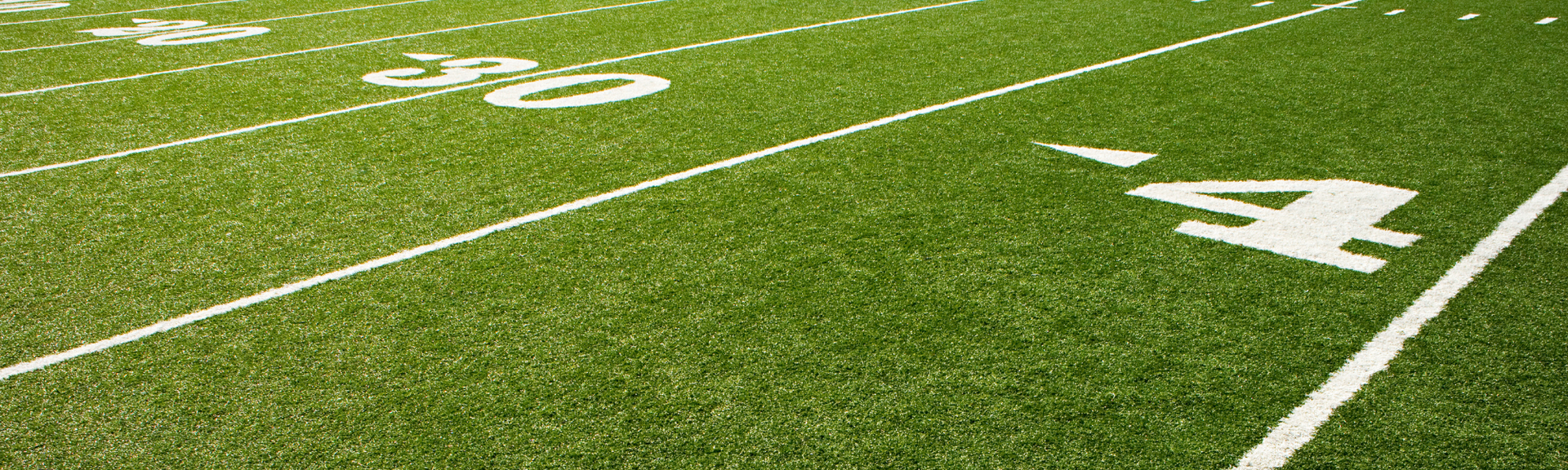 Green football field with white yard lines and a large painted number 40