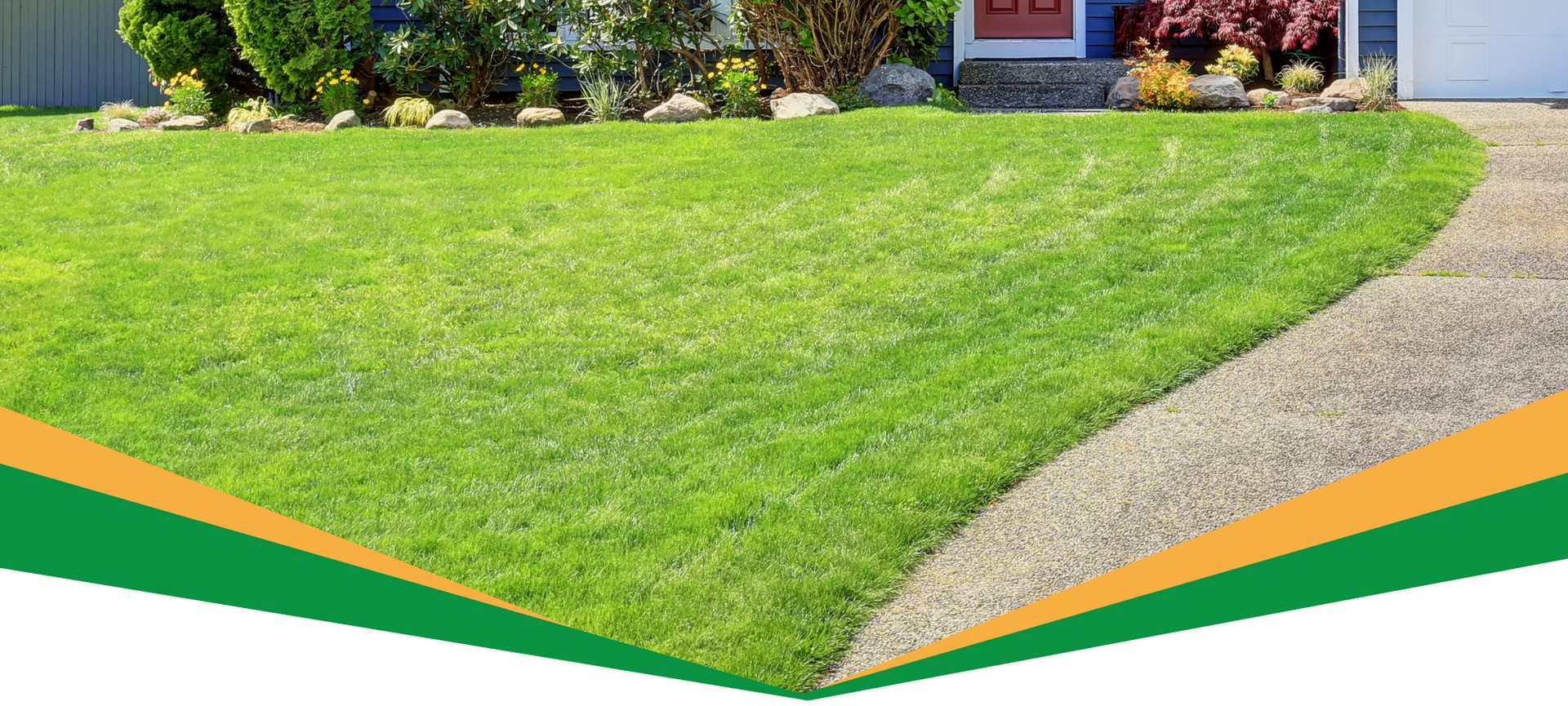 Green lawn with a curved gravel path leading to a house entrance and flower beds.