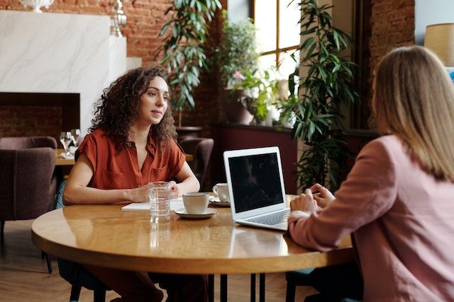 two people sitting at a table for a tenant screening interview