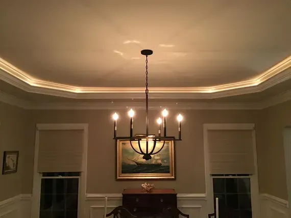 Dining room with chandelier, recessed ceiling lighting, artwork, and windows.
