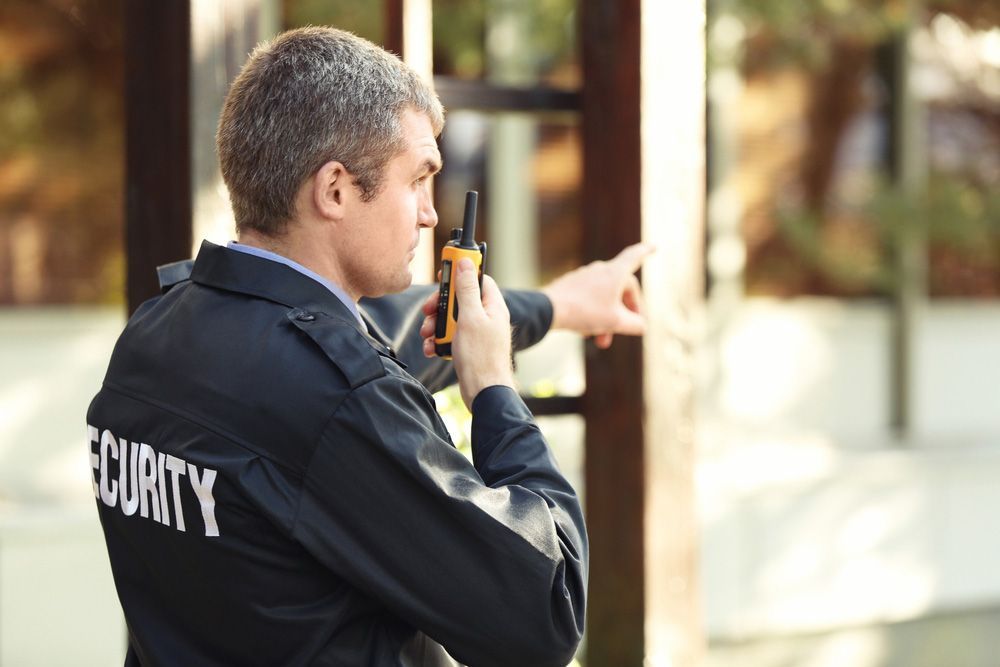 A Security Guard Is Talking On A Walkie Talkie — Professional Security Guards in Toowoomba, QLD