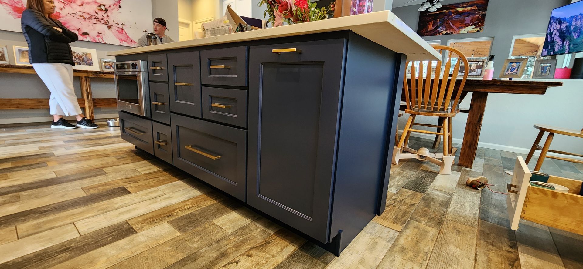 Kitchen island with dark blue cabinets, gold hardware, and a light-colored countertop.