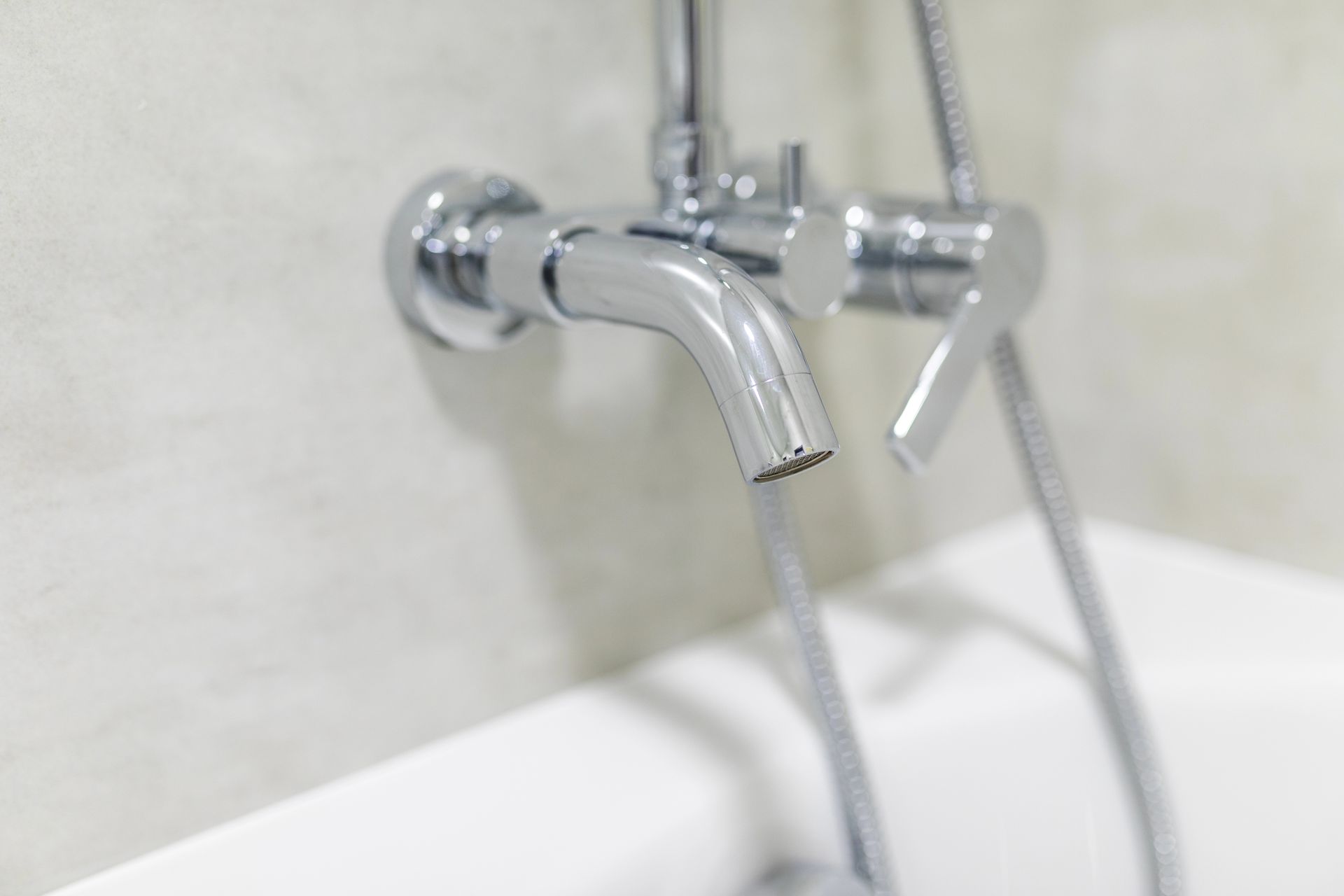 Un primer plano de un grifo de bañera del que sale agua.