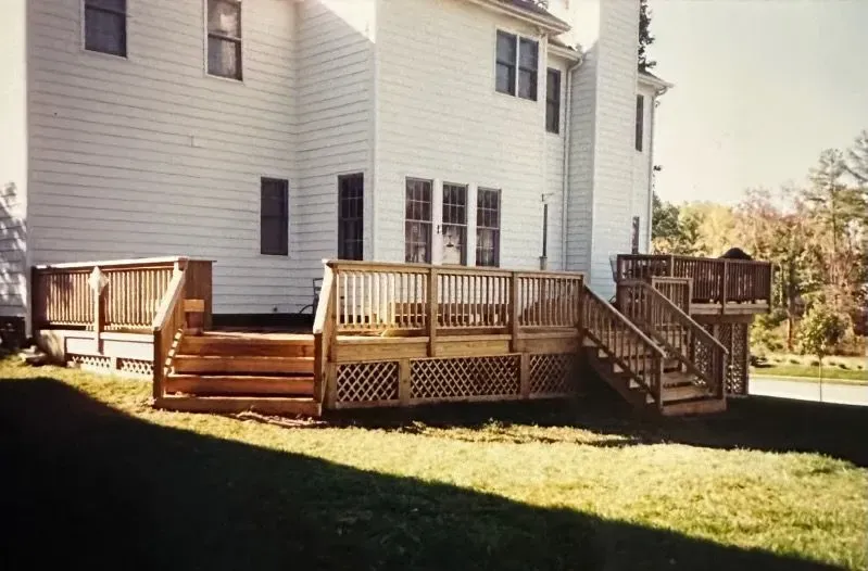 A large white house with a wooden deck in front of it