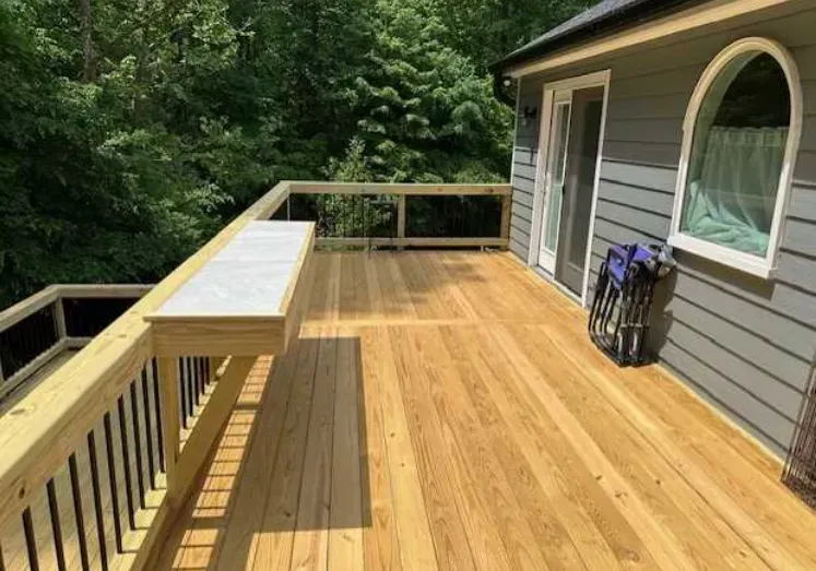 A large wooden deck on the side of a house.