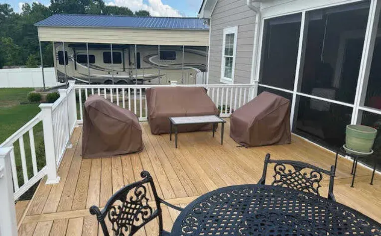 There is a screened in porch with a table and chairs on it.