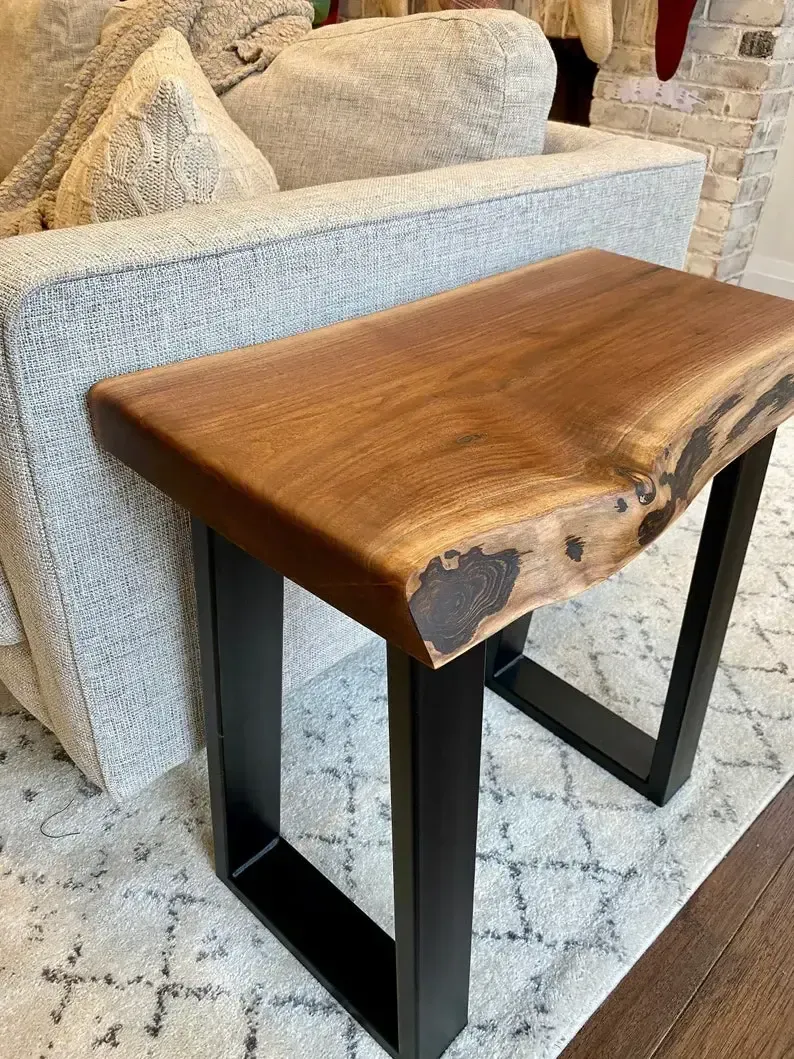 A wooden table is sitting next to a couch in a living room.