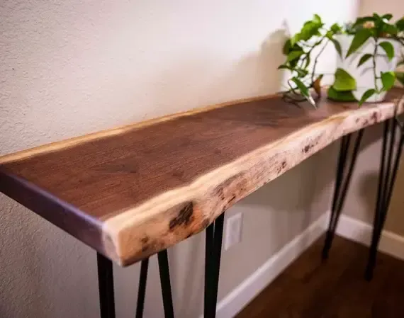 A wooden table with hairpin legs and a plant on top