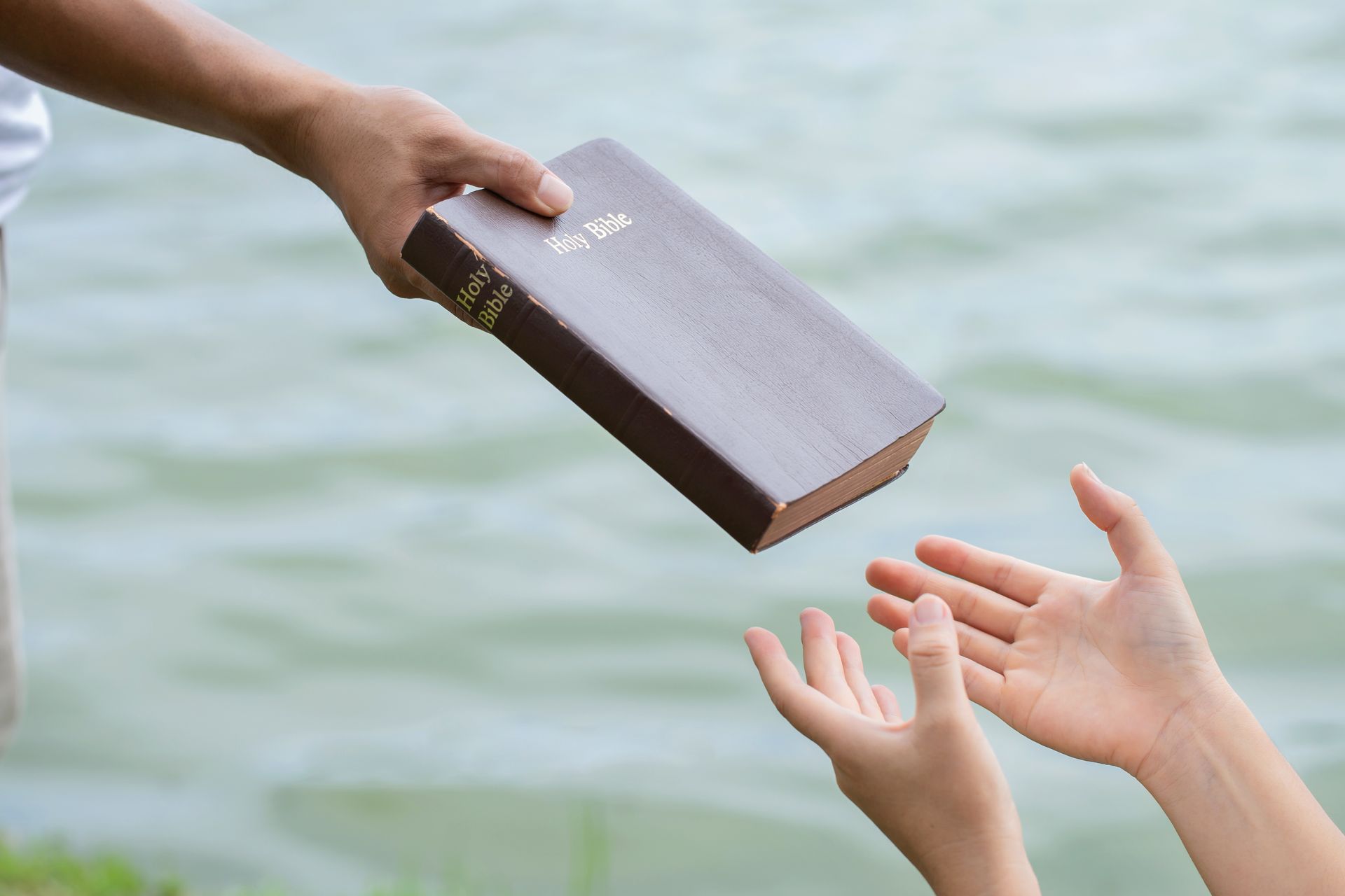 A person is giving a bible to another person.