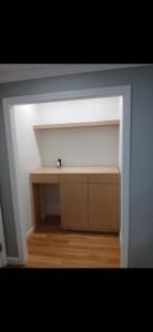 Built-in kitchenette nook with sink, cabinet, and wood floor in a recessed wall alcove