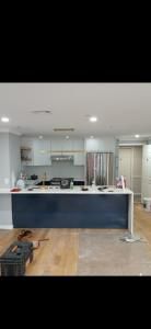Bright kitchen with dark island, white cabinets, and wood flooring in a modern open room