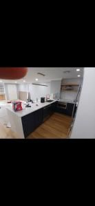 Modern kitchen with white cabinets, black countertops, wood floors, and a central island
