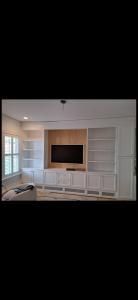 Bright living room with built-in shelves and a large wall-mounted TV
