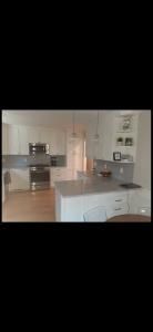 Modern kitchen with white cabinets, gray island, and stainless steel appliances
