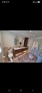 Modern bathroom with a double vanity, large mirror, freestanding tub, and marble tile floor.