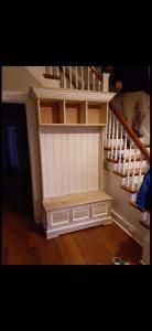Built-in white storage cabinet under a staircase in a home interior
