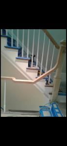 Indoor staircase with white railing and blue patterned floor tiles