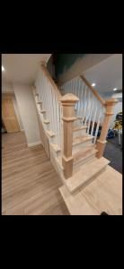 Wooden staircase with white railing in a bright indoor home interior.