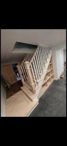 Indoor staircase with white railings in a home, viewed from the lower floor.