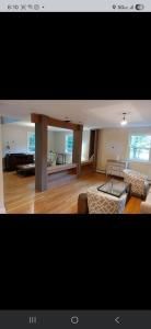 Modern living room with wood floors, large mirror divider, sofa, and coffee table.