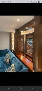Sunlit living room with blue sofa and large wooden-framed window seats