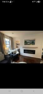 Cozy living room with a fireplace, armchair, and large windows letting in daylight