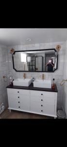 Modern bathroom vanity with double sinks, large mirror, and wall sconces