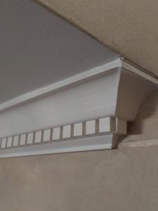 Close-up of white crown molding and decorative trim at a ceiling corner