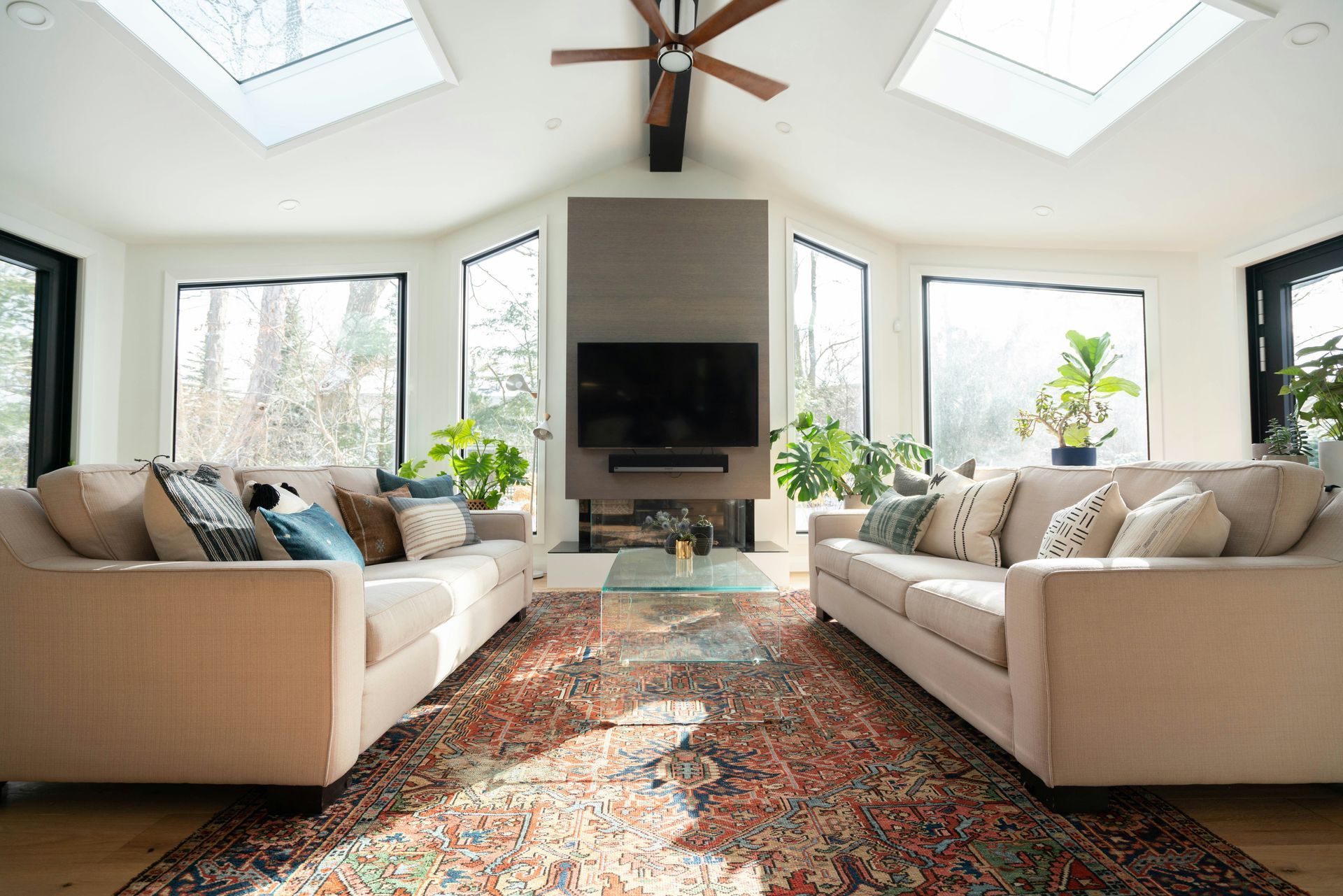 A woman is cleaning a couch in a living room.