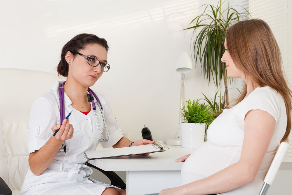 Doctor Consulting With a Pregnant Patient in a Bright Clinic Office — HealthHub Taree in Taree, NSW