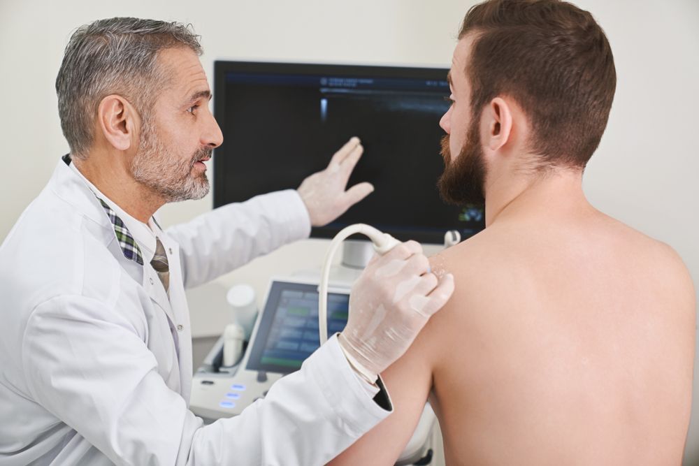 Doctor Performing an Ultrasound Exam on a Patient’s Back in a Clinic Room — HealthHub Taree in Taree, NSW