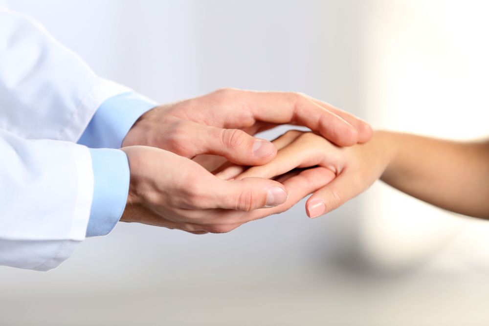 Two Hands Gently Holding Each Other Against a Soft White Background — HealthHub Taree in Taree, NSW