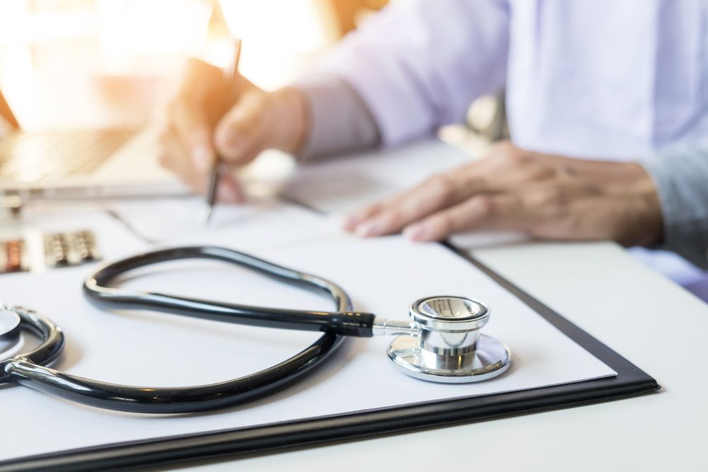 Doctor’s Hands at a Desk With a Stethoscope on a Clipboard — HealthHub Taree in Taree, NSW