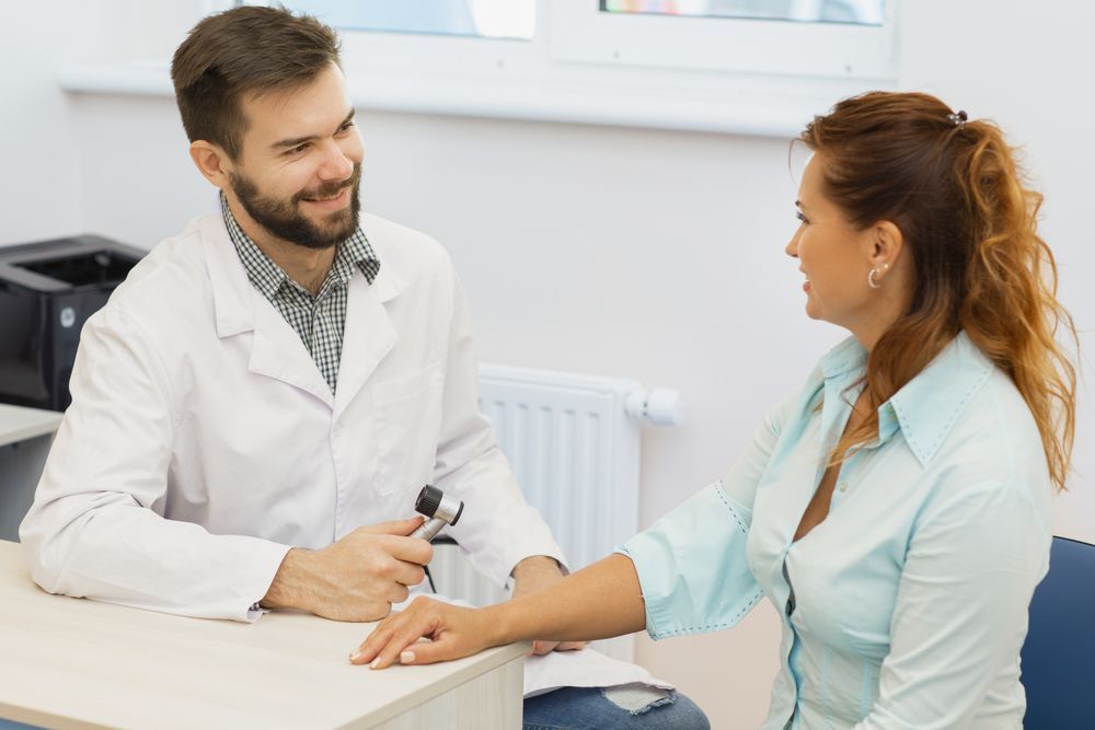 Doctor Taking a Patient's Pulse in a Bright Clinic Room — HealthHub Taree in Taree, NSW