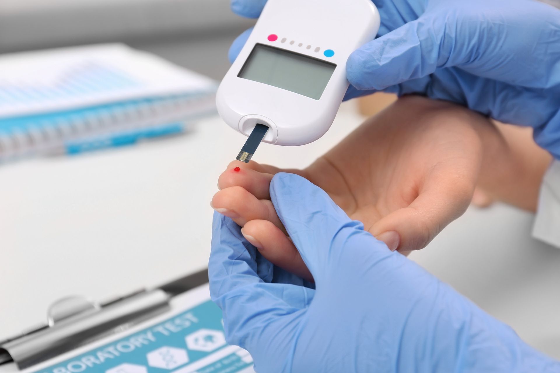 Gloved Hands Using a Blood Glucose Meter to Test a Fingertip Blood Sample — HealthHub Taree in Taree, NSW