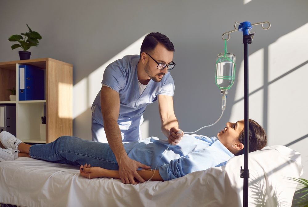 Doctor Checking on Patient in Hospital Bed Beside an IV Drip — HealthHub Taree in Harrington, NSW