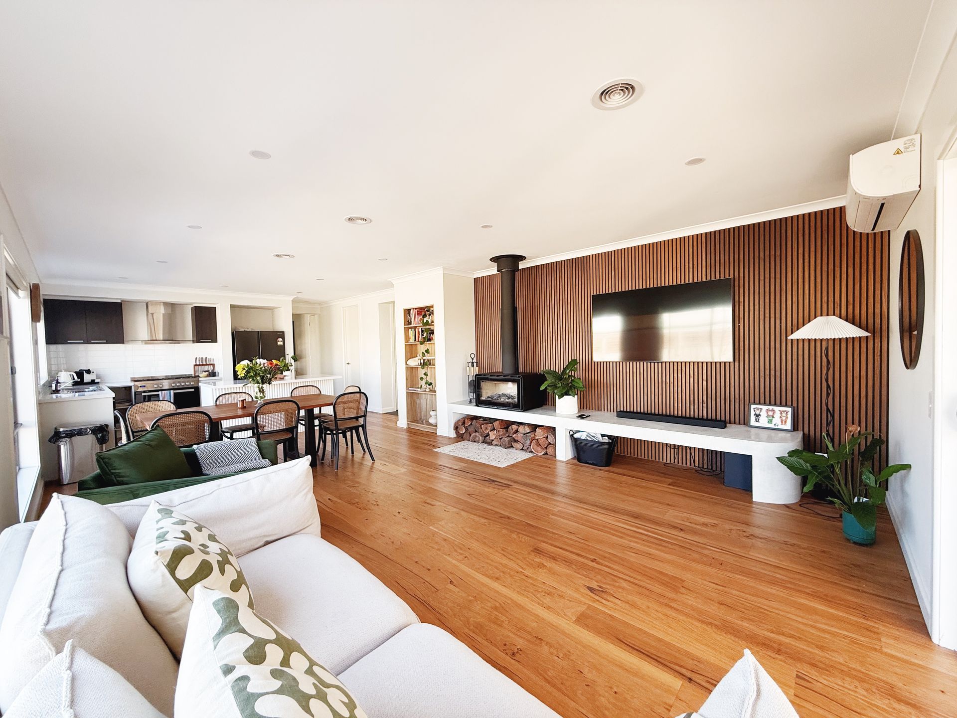 Modern kitchen with blue and wood cabinets, white countertops, and wood flooring.