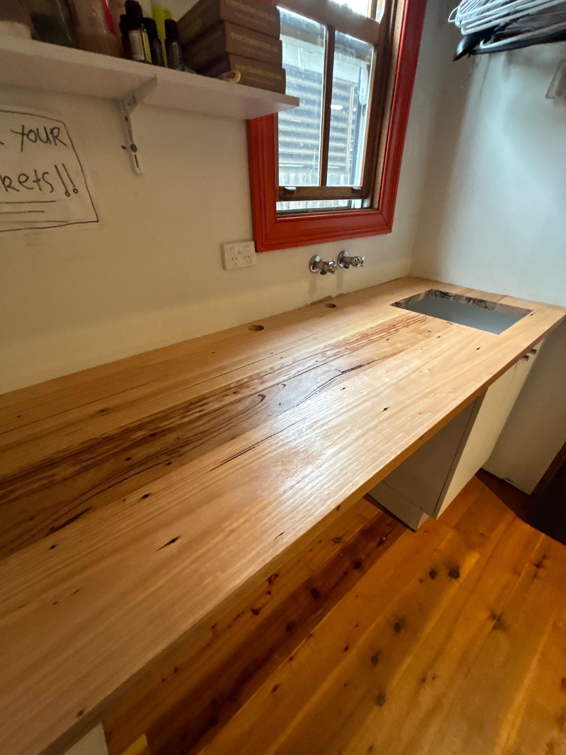 A kitchen with a wooden counter top and a sink.