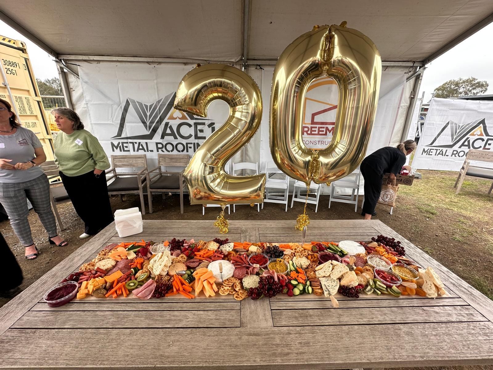 A catered table in front of a metal roofing business, with giant gold