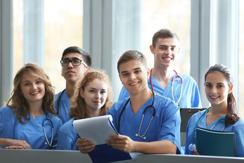 A group of medical students are posing for a picture in a hospital.