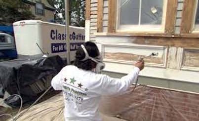 Person in a white shirt and black cap points at a shop window while standing on a city sidewalk