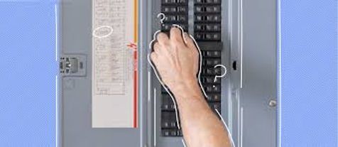 Hand adjusting breakers in an electrical panel with open gray door on a blue wall