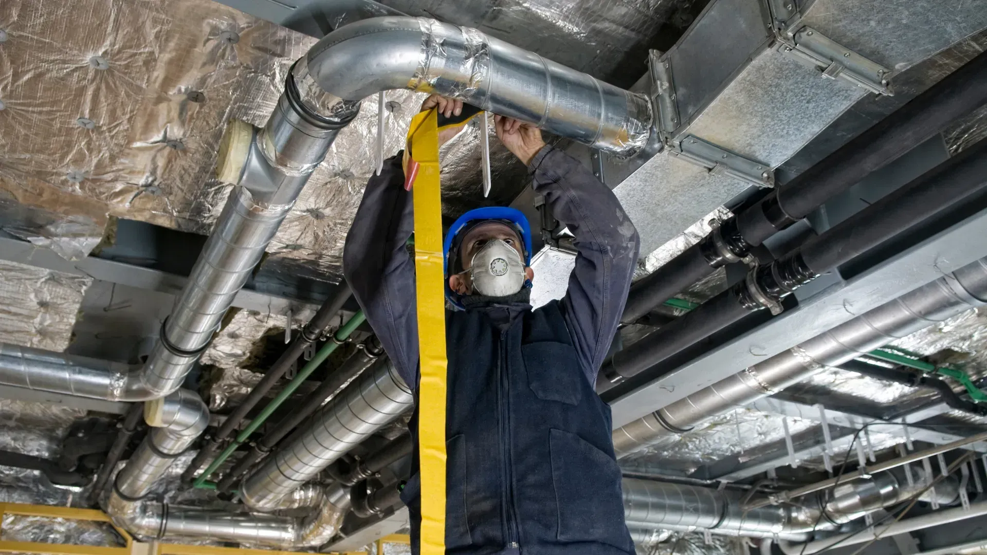 A man is measuring a pipe with a tape measure.