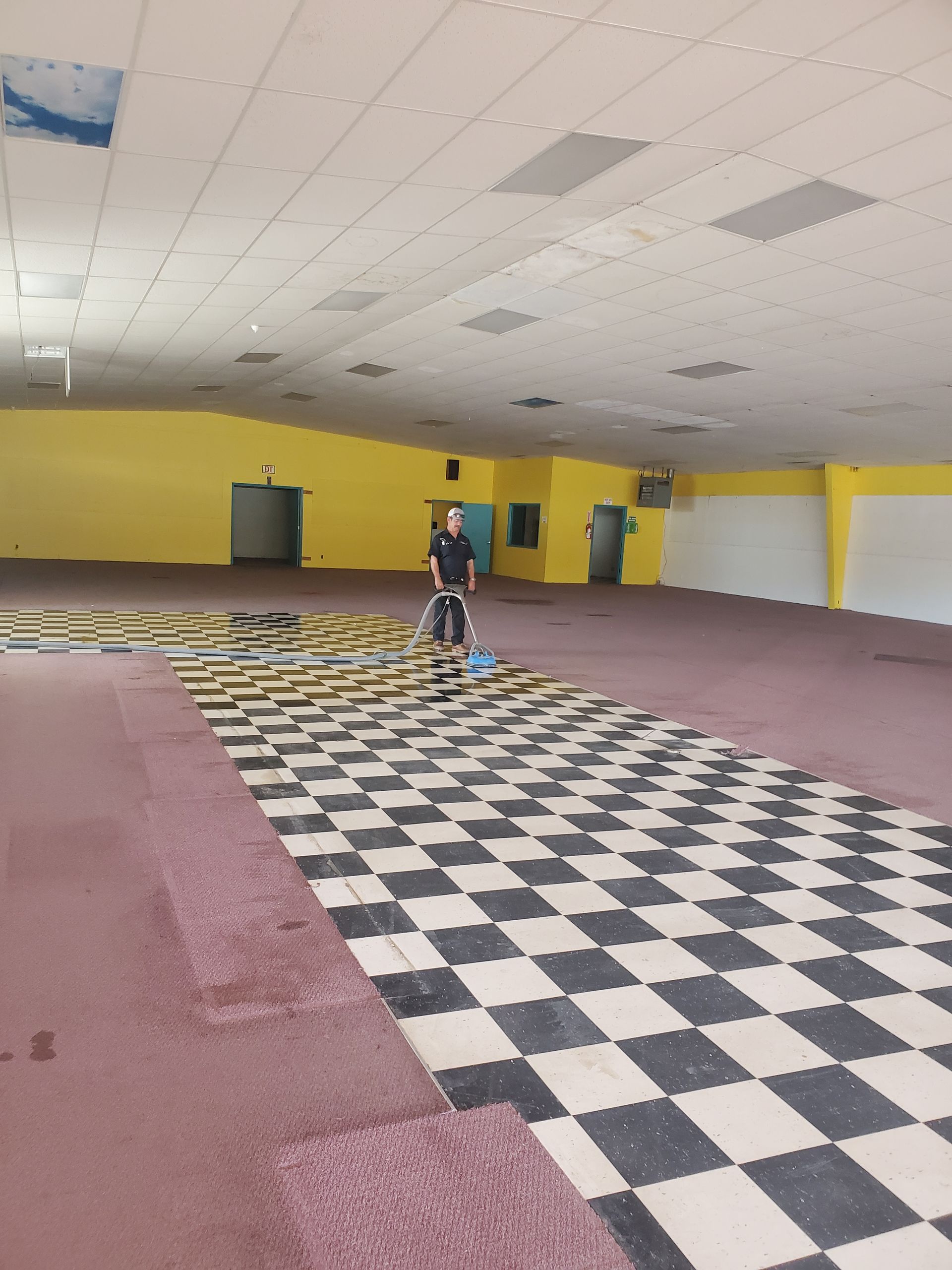 A man is cleaning the floor with a machine.